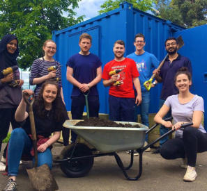 corporate volunteering group pose for photo during session helping community garden