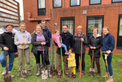 group posing for camera as part of tree planting session at Manchester GP surgery