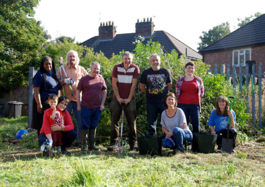 growing manchester event group pose for photo in community garden